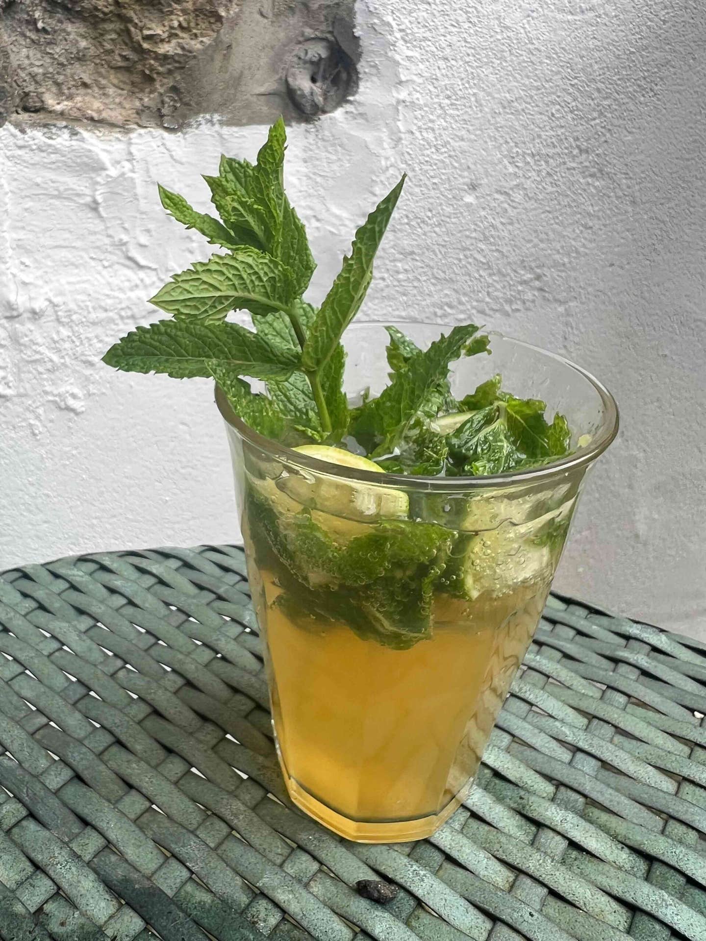 Light and healthy mocktail recipe: Alcohol-free mojito on a patio table with sprigs of mint